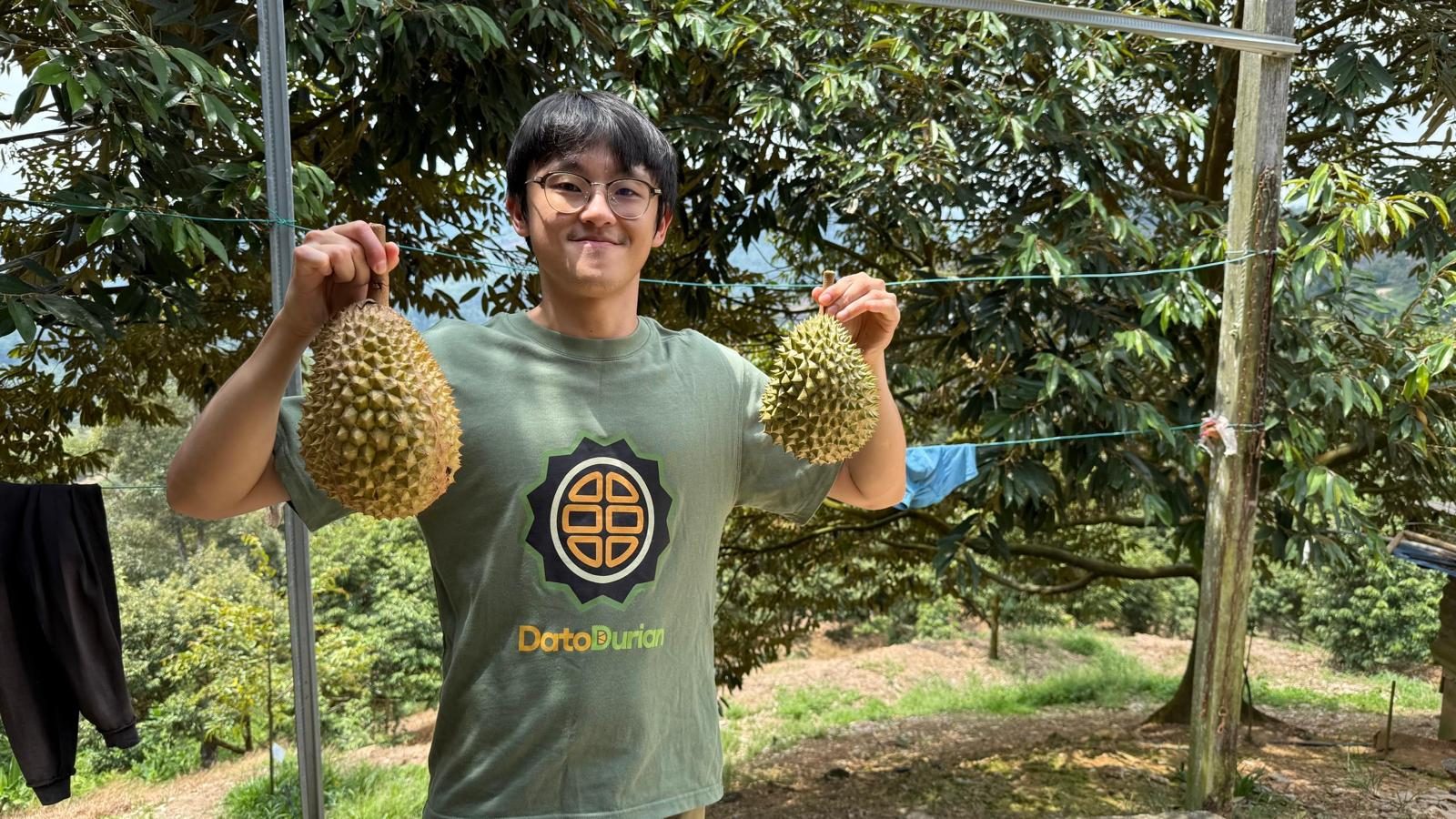 Bobby Sim holding two durians at the DatoDurian farm in Raub, Pahang